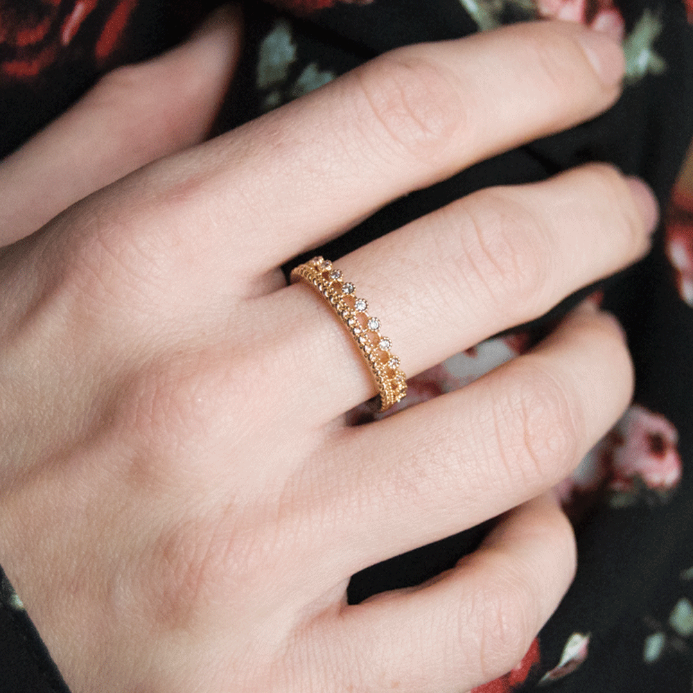 Gold-plated rhinestone ring worn on middle finger